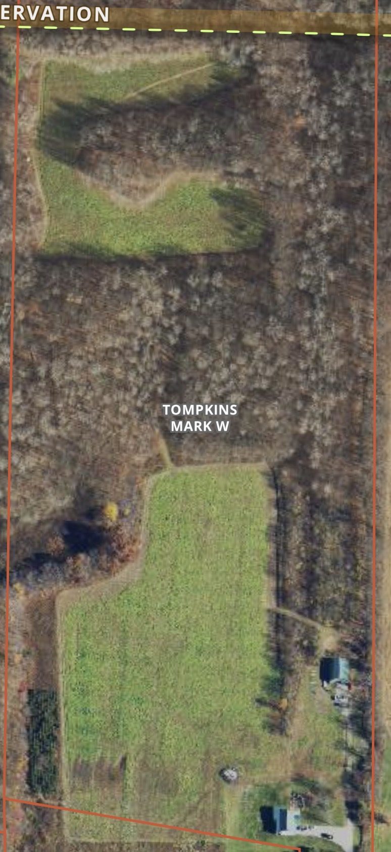 Aerial view of the Tompkins Farm property showing fields, woods, and pond