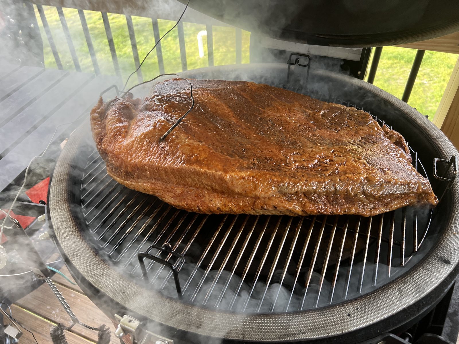 A whole brisket smoking on the grill at a Tompkins family cookout